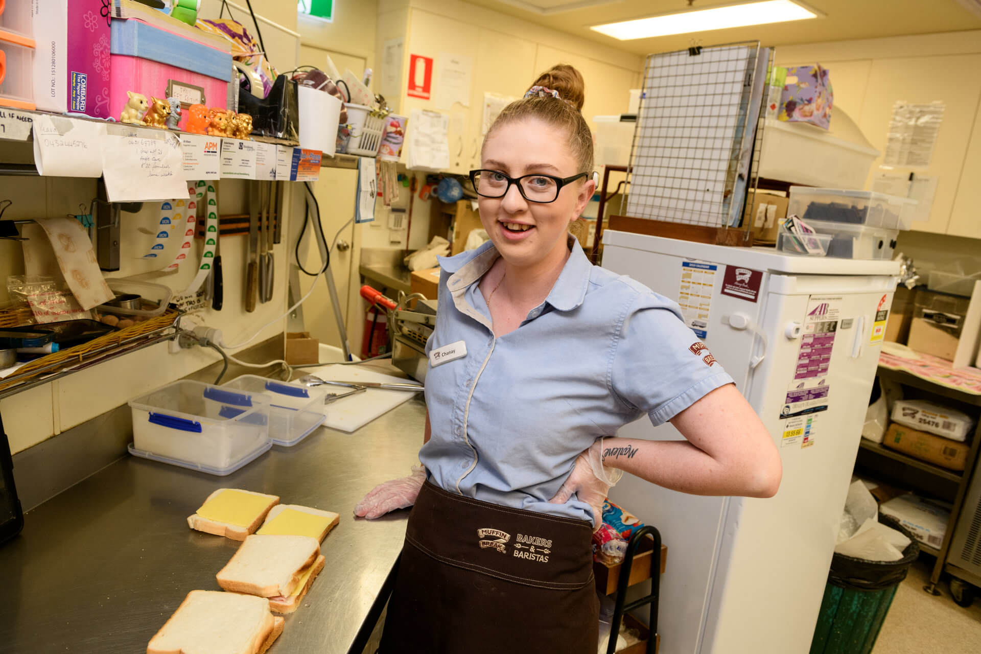 Chanay smiles working behind the counter of a cafe