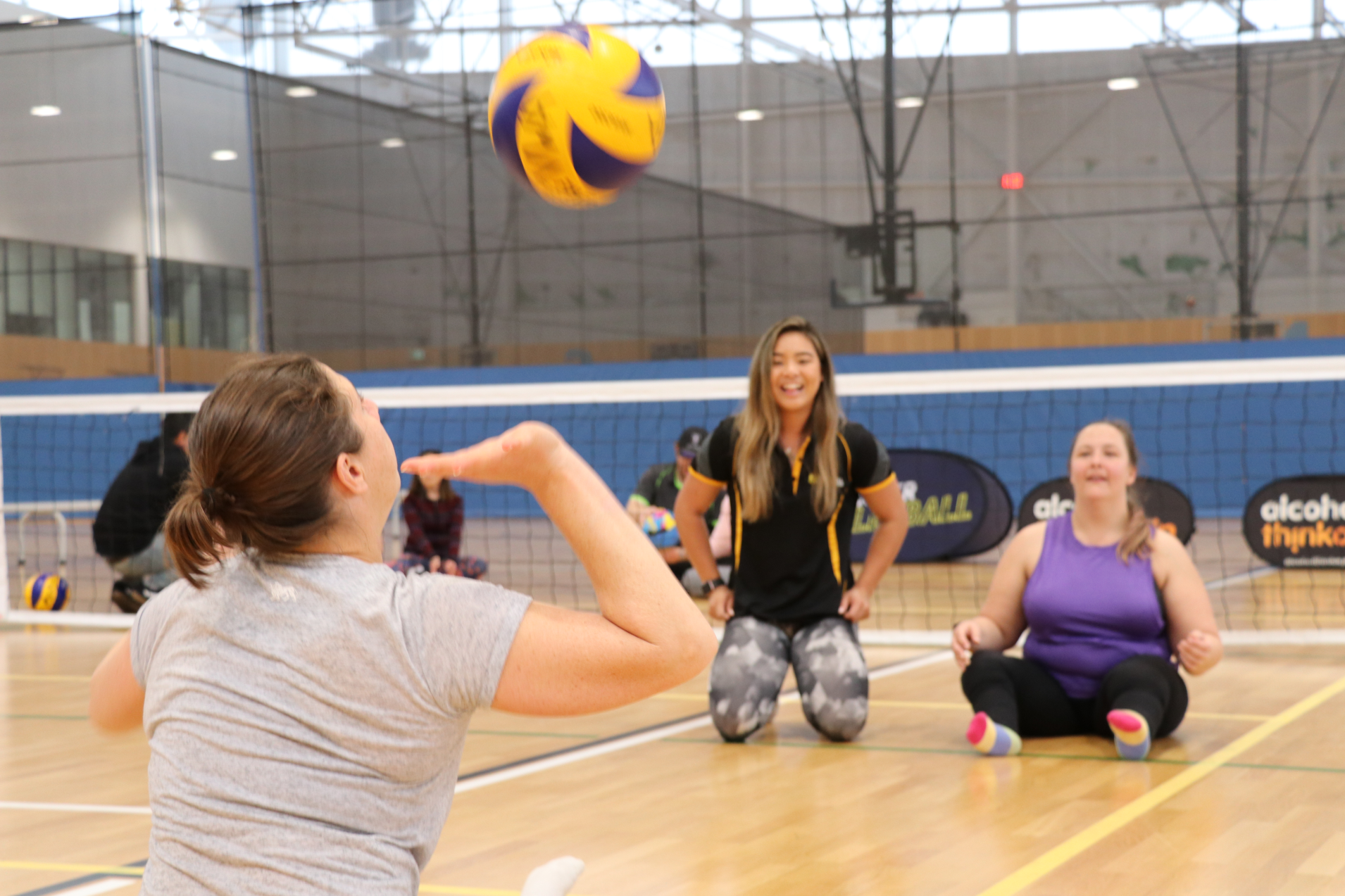 Players sitting on a court about to hit a volleyball