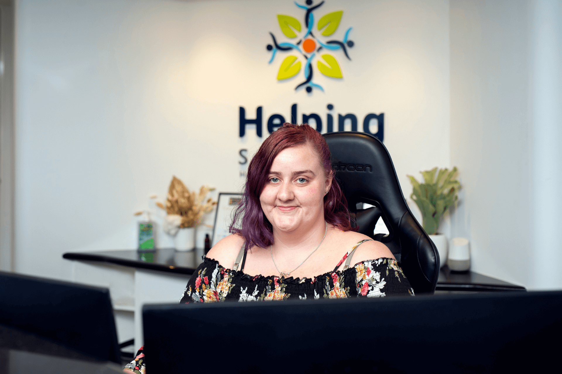 Kristie smiling from behind the reception desk 