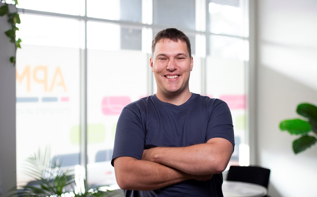 Alexander smiles with his arms folded