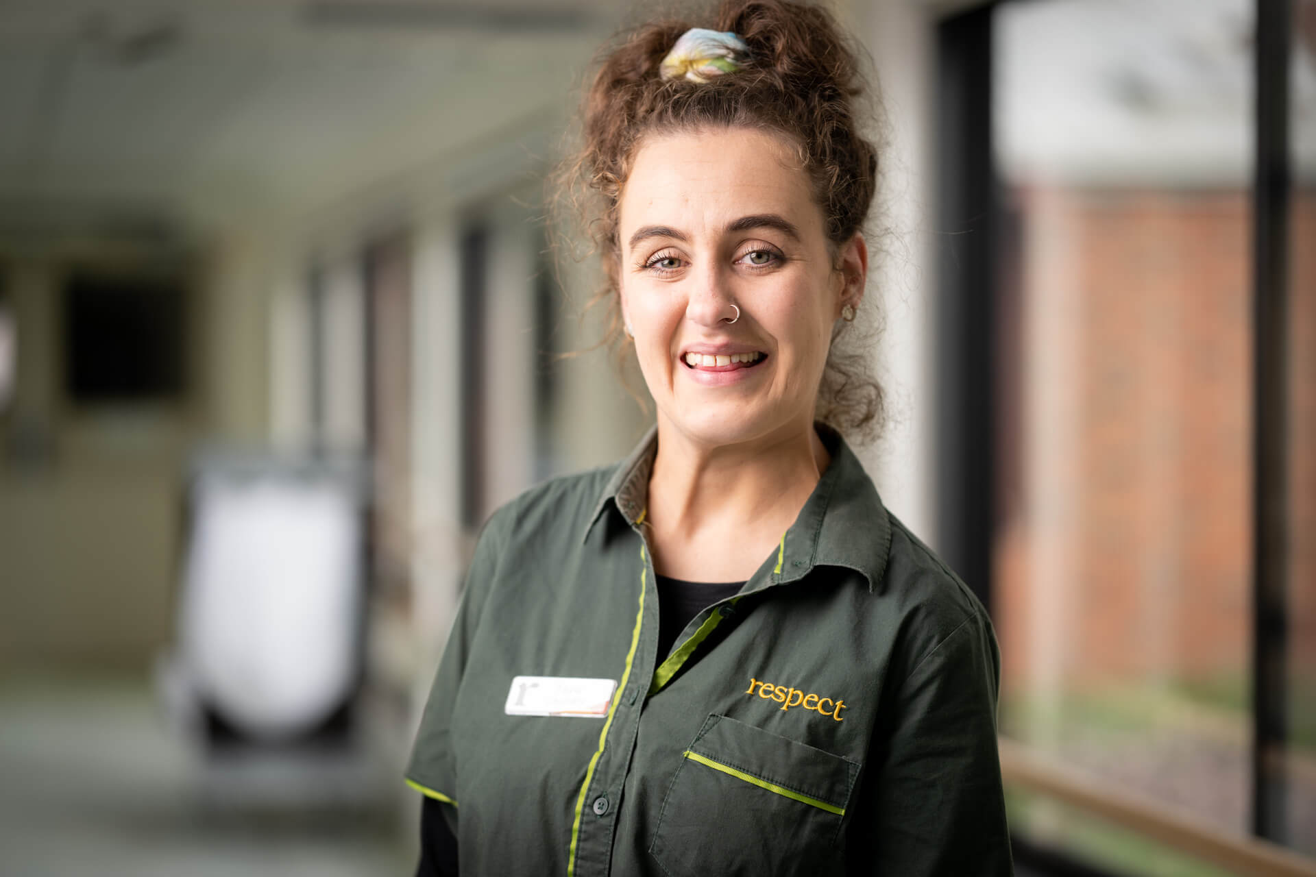 DES participant Tayla smiles in her work uniform 