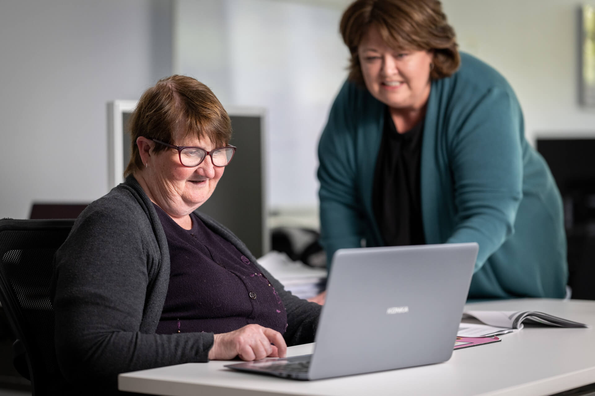Ruth working on a course at a laptop in her local APM branch
