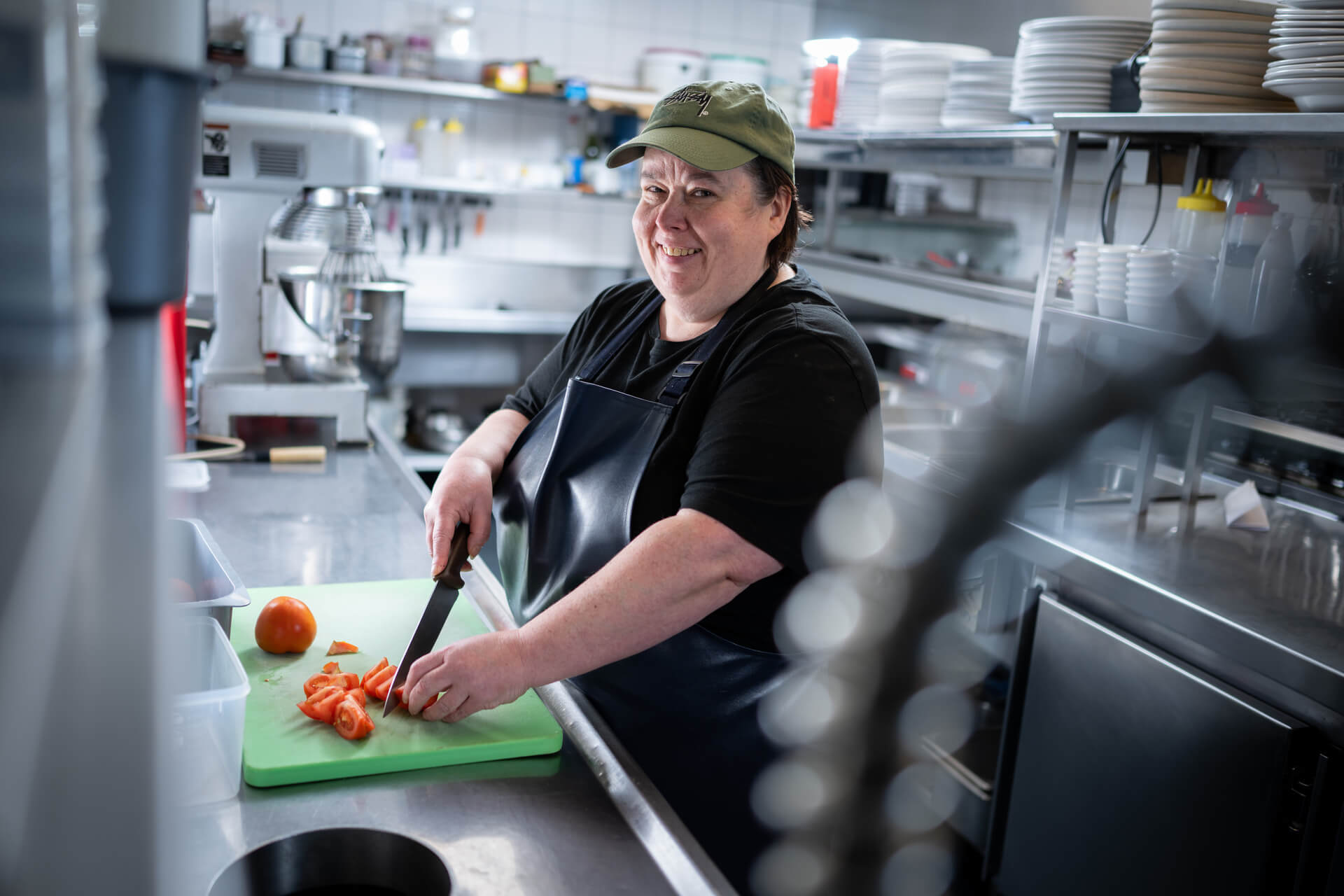 DES participant Melissa smiles as she prepares food in the kitchen