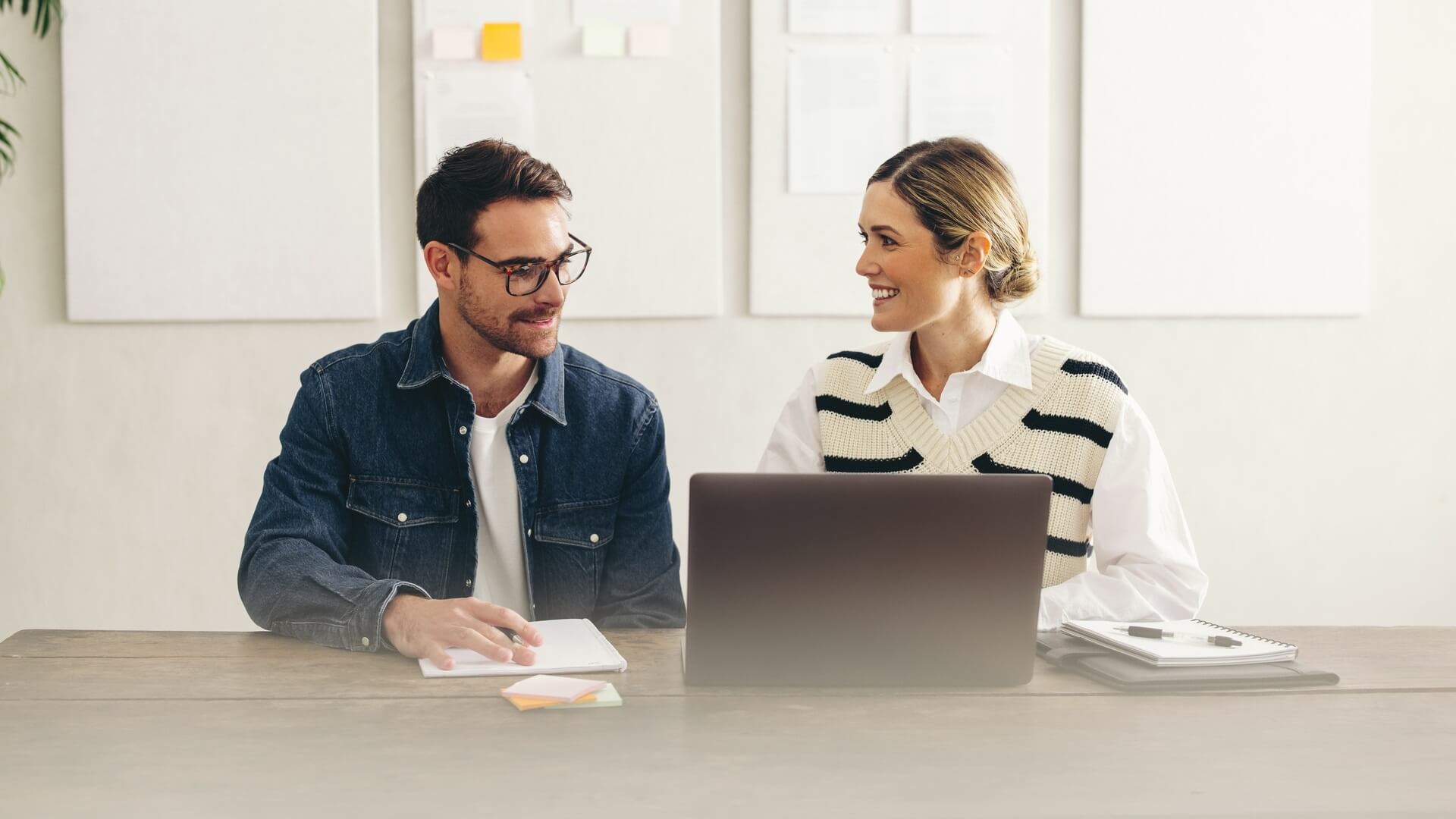 Two co-workers sitting at a desk having a meeting