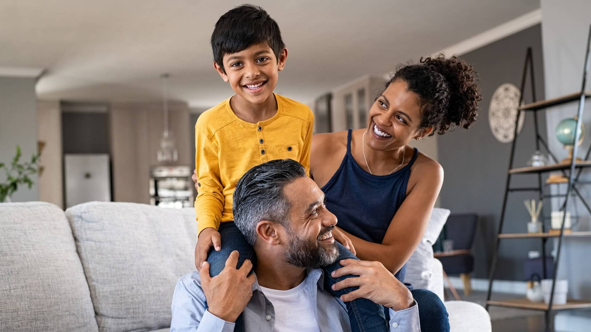 A smiling family sitting together in front of the couch